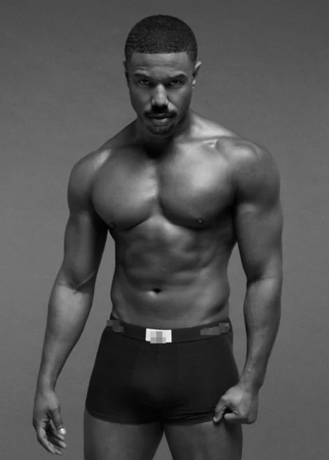 Homem musculoso com corpo definido, vestindo cueca preta, olhando para a câmera.